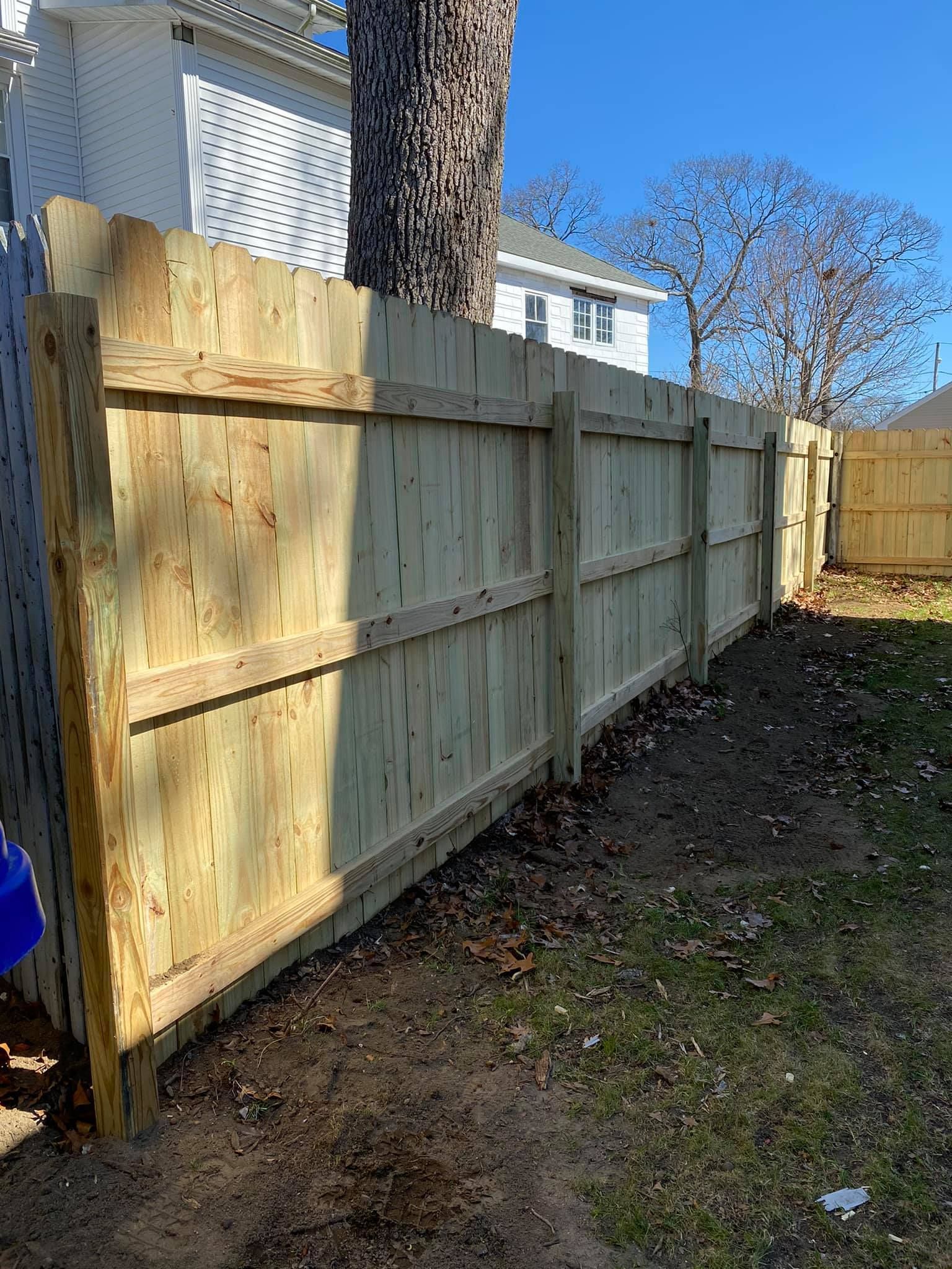 a wooden fence is in the backyard of a house .