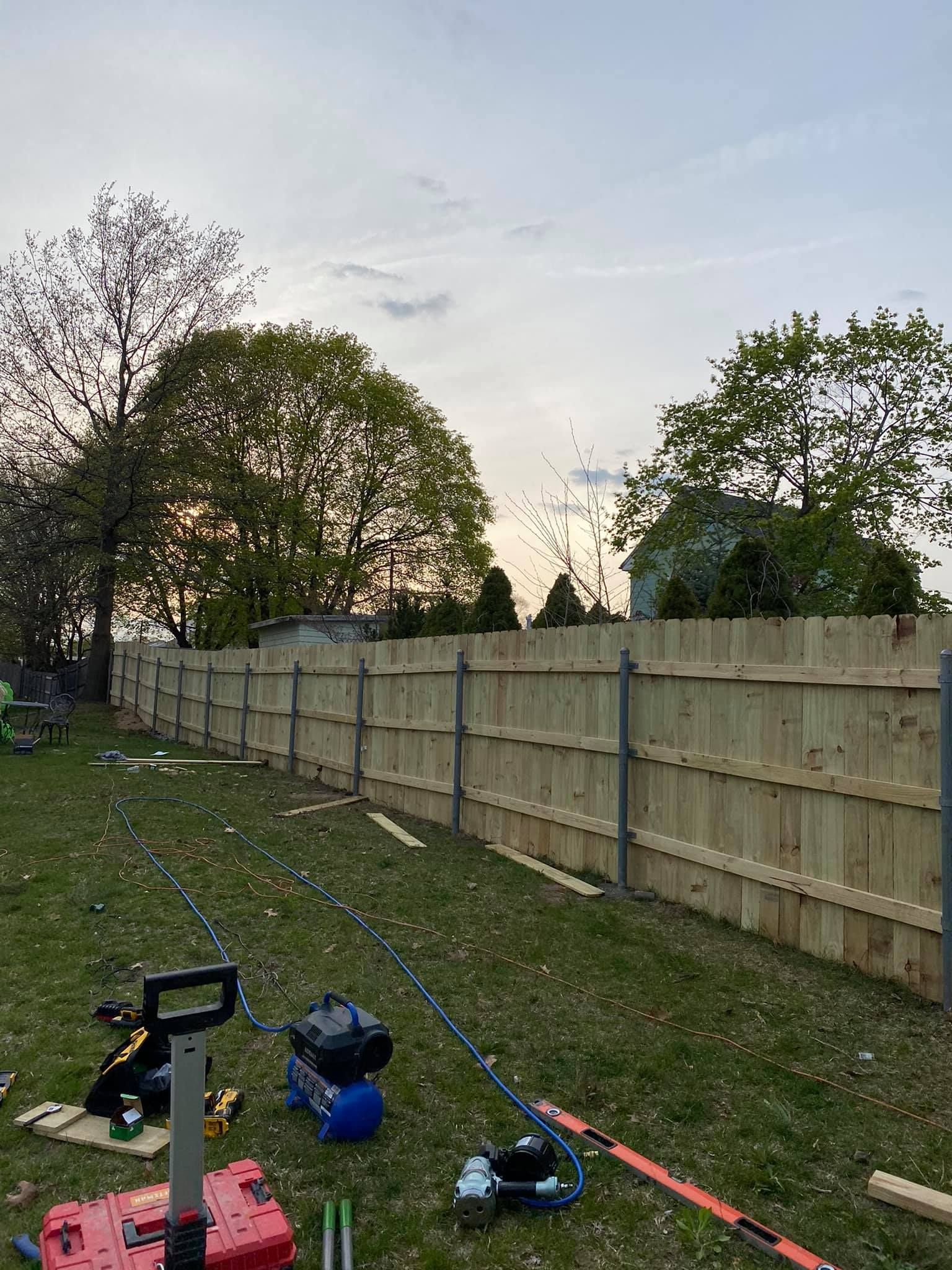 a wooden fence is being built in a backyard .