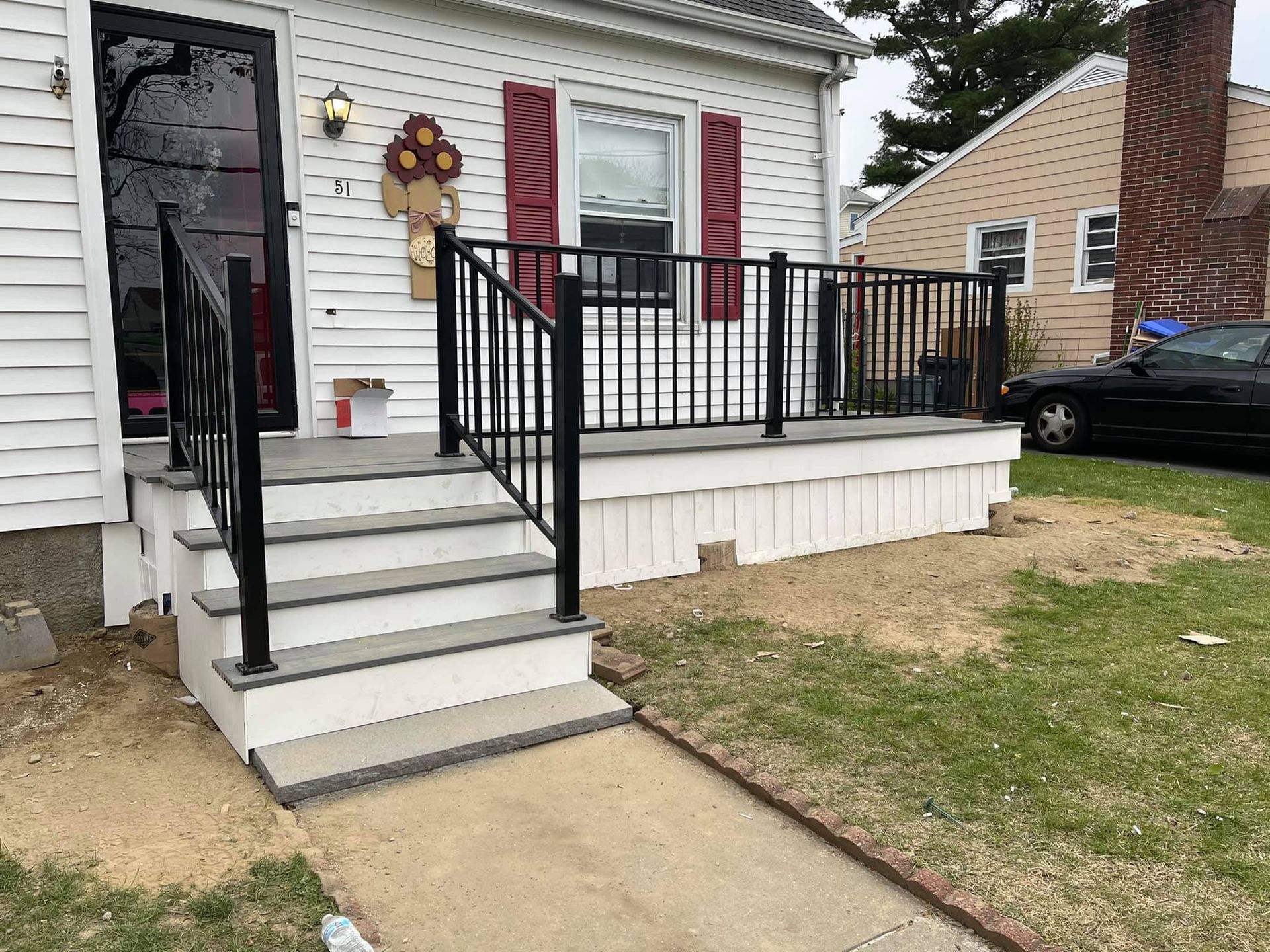 a white house with a black railing and stairs