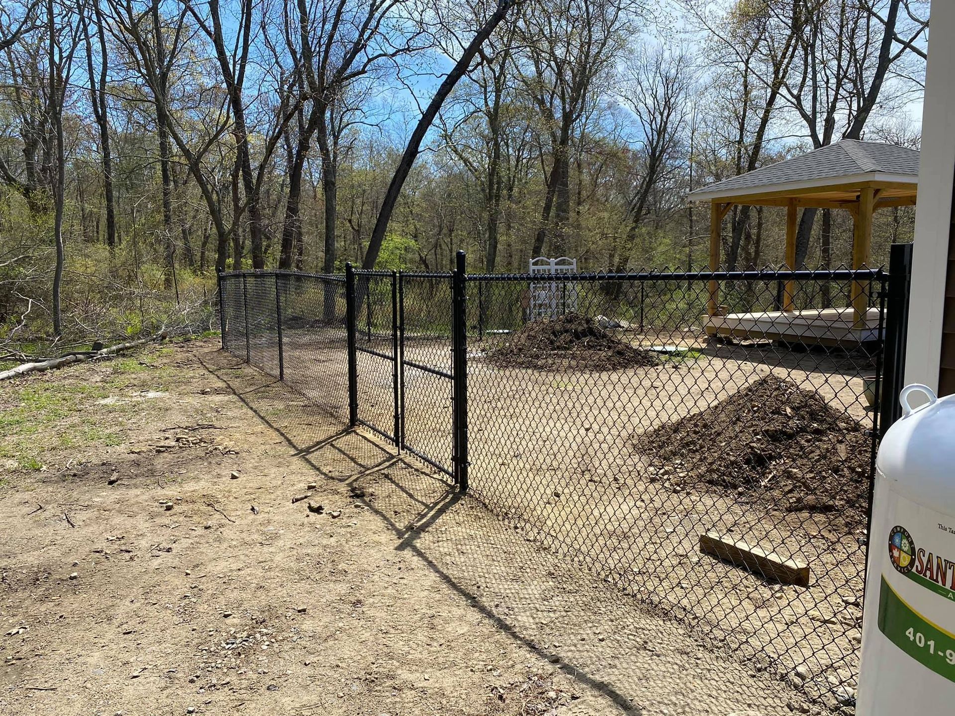 a chain link fence is being built in the middle of a dirt field .