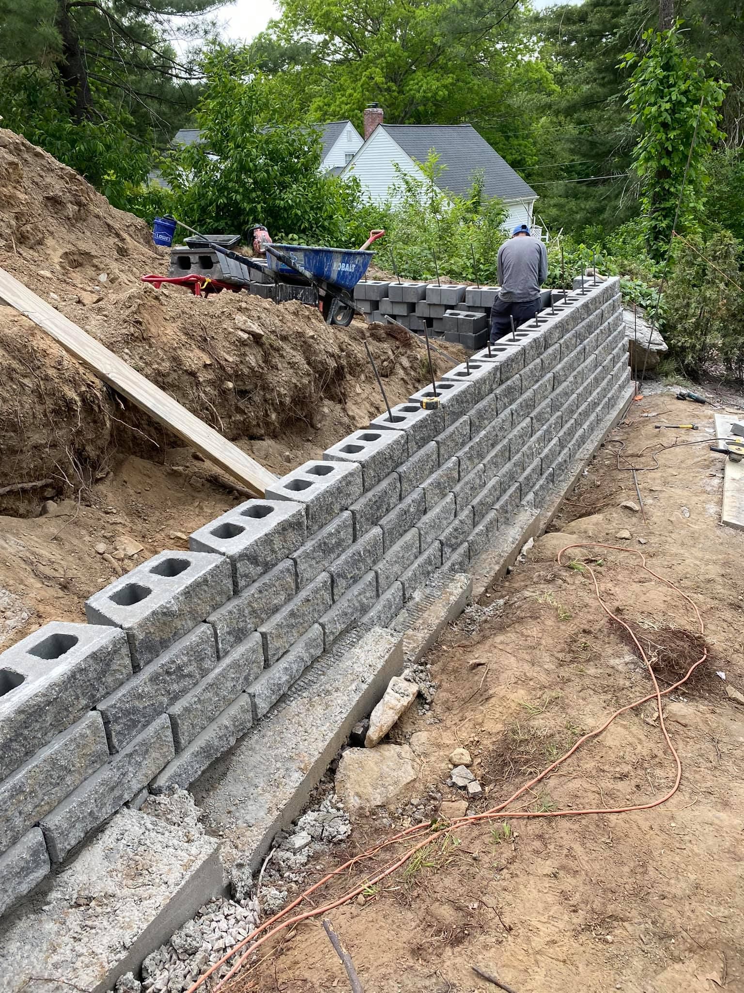 a brick wall is being built on top of a dirt hill .