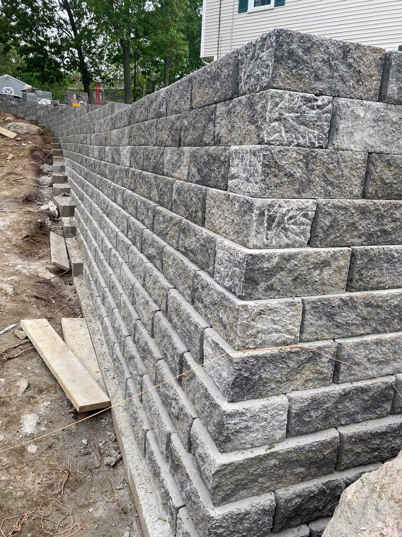 a large brick wall is being built in front of a house .