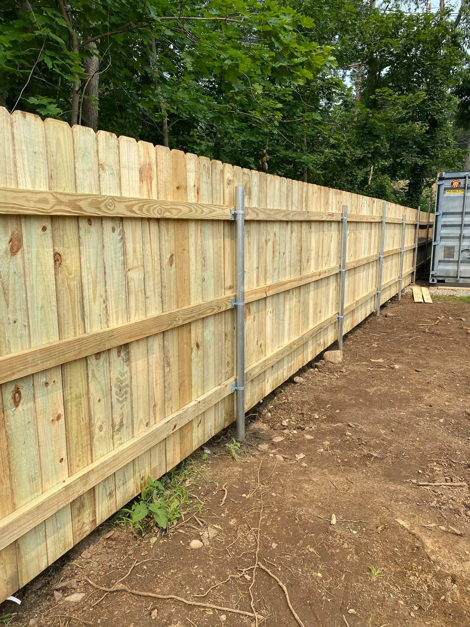 a wooden fence is being built in a dirt field .