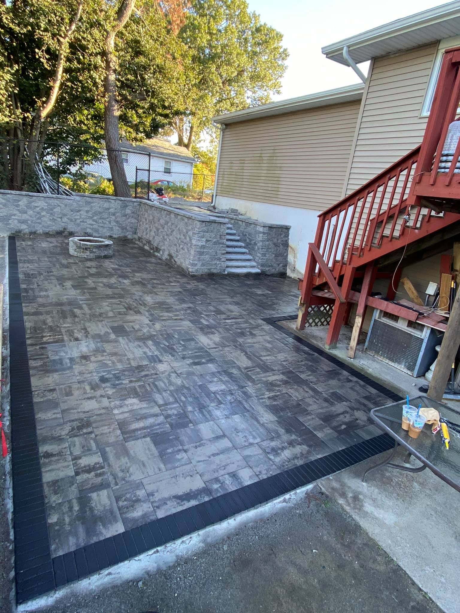 a patio is being built in front of a house with stairs .