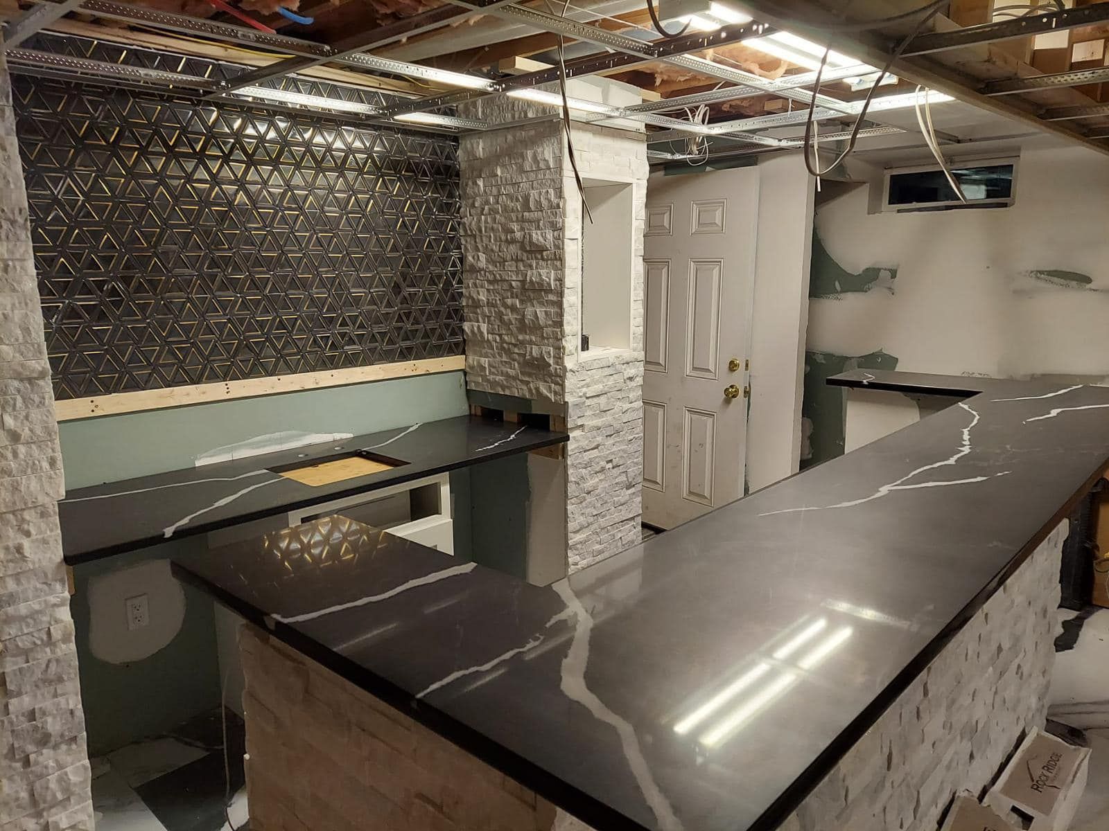 a kitchen with a black counter top and a white door .