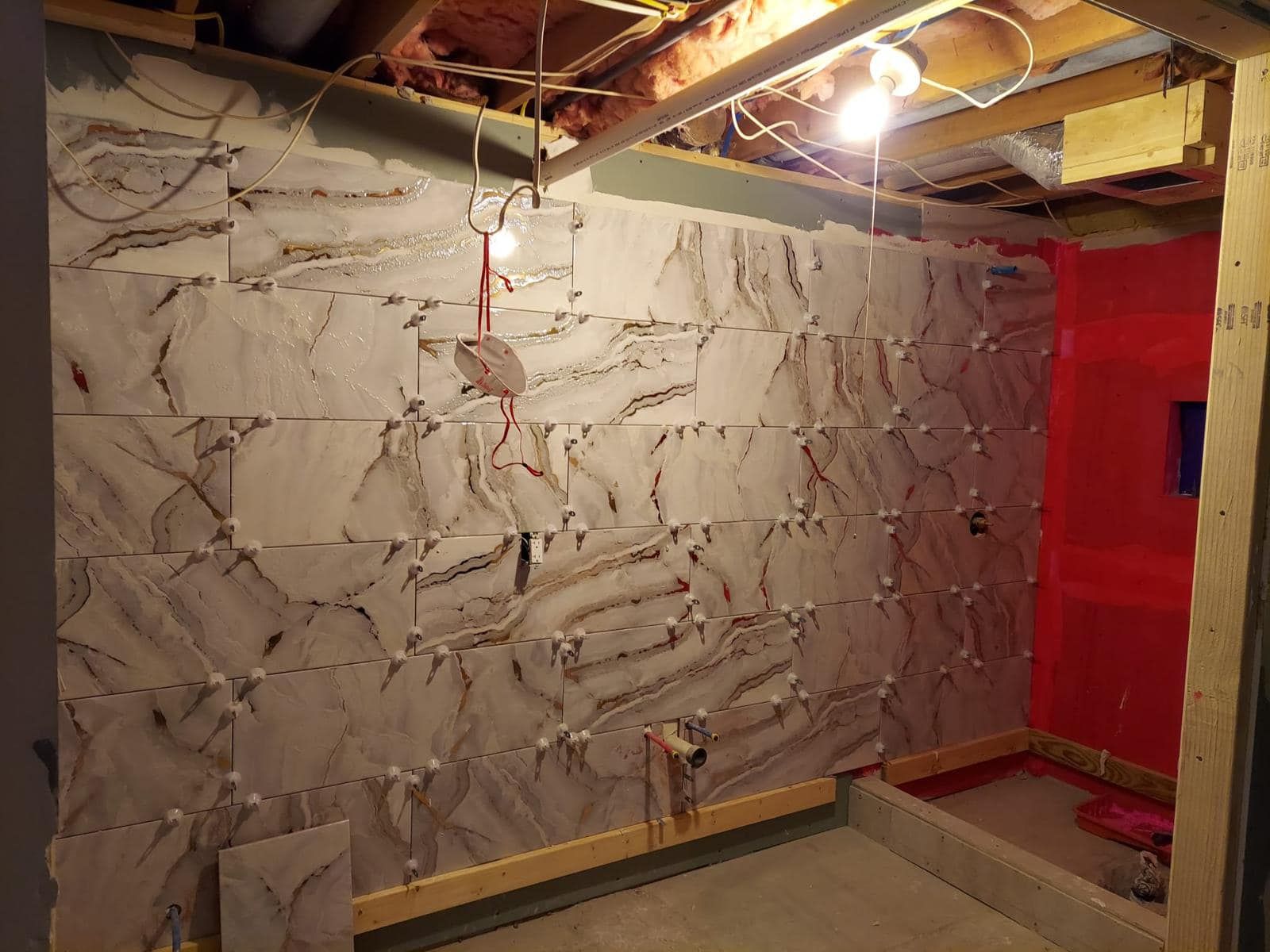 a room under construction with a brick wall and a red wall .
