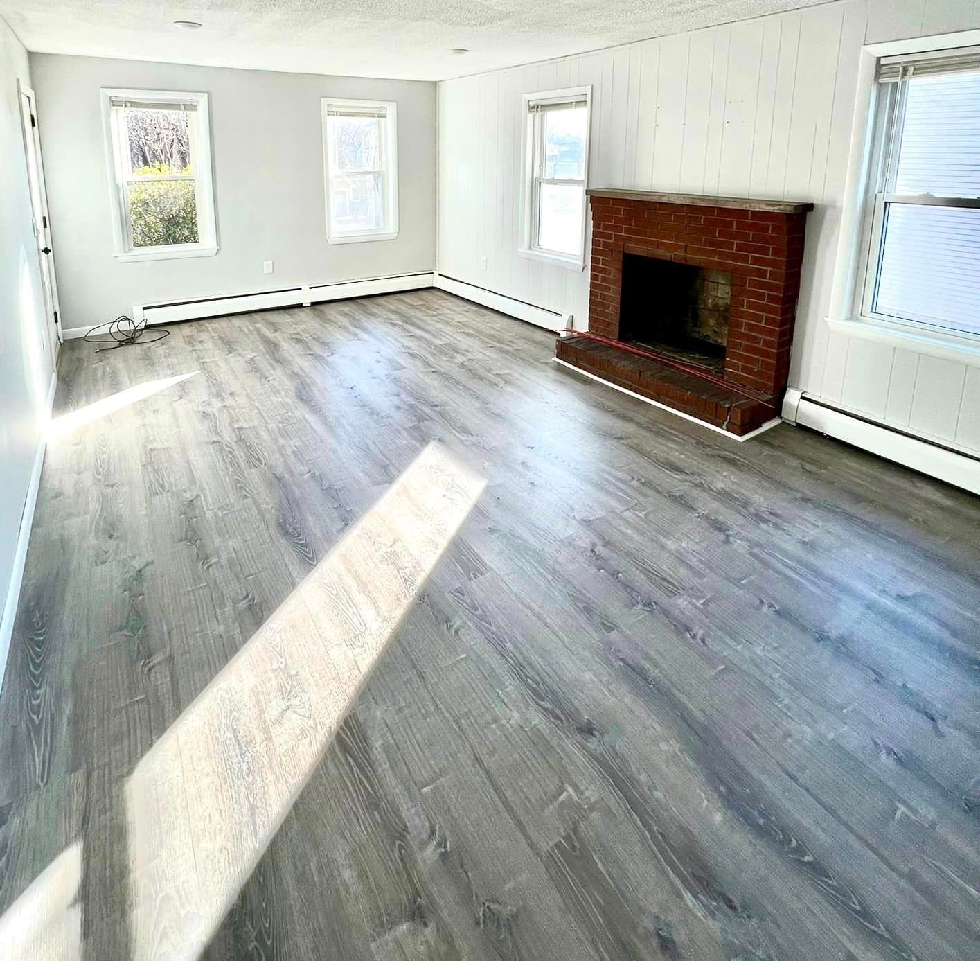 a living room with hardwood floors and a fireplace .