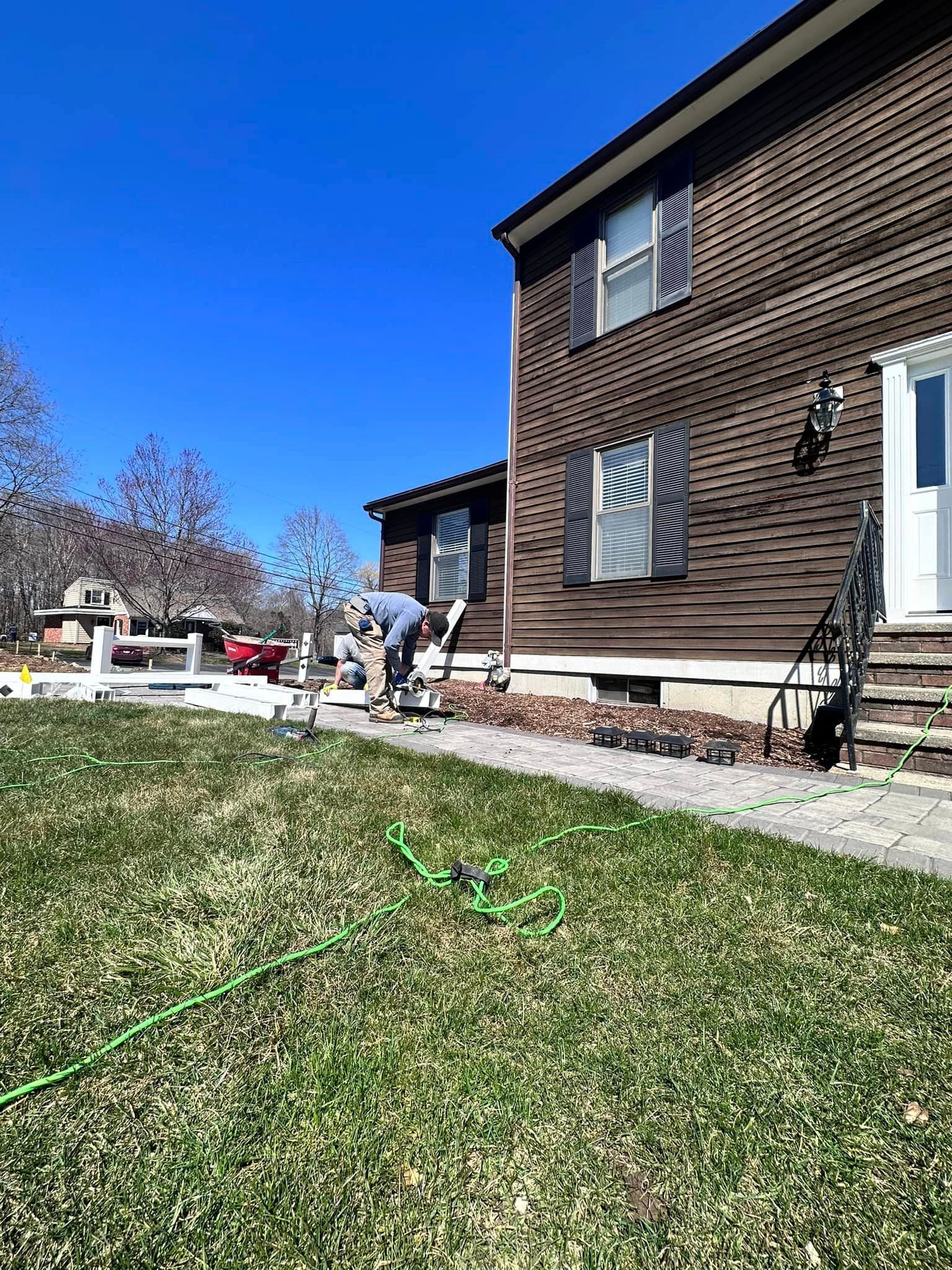 a man is standing in front of a brown house .
