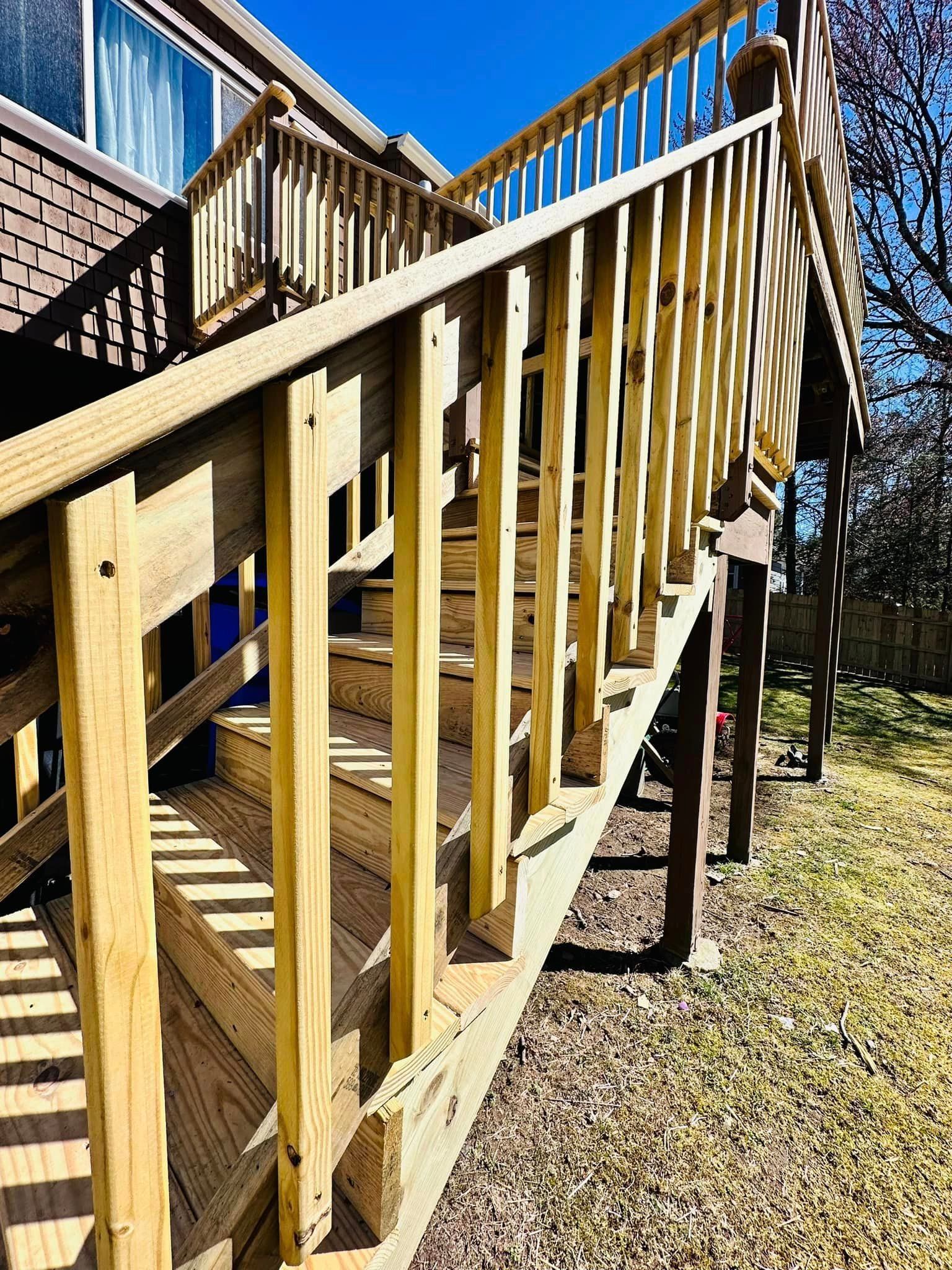 a wooden deck with stairs leading up to a house .