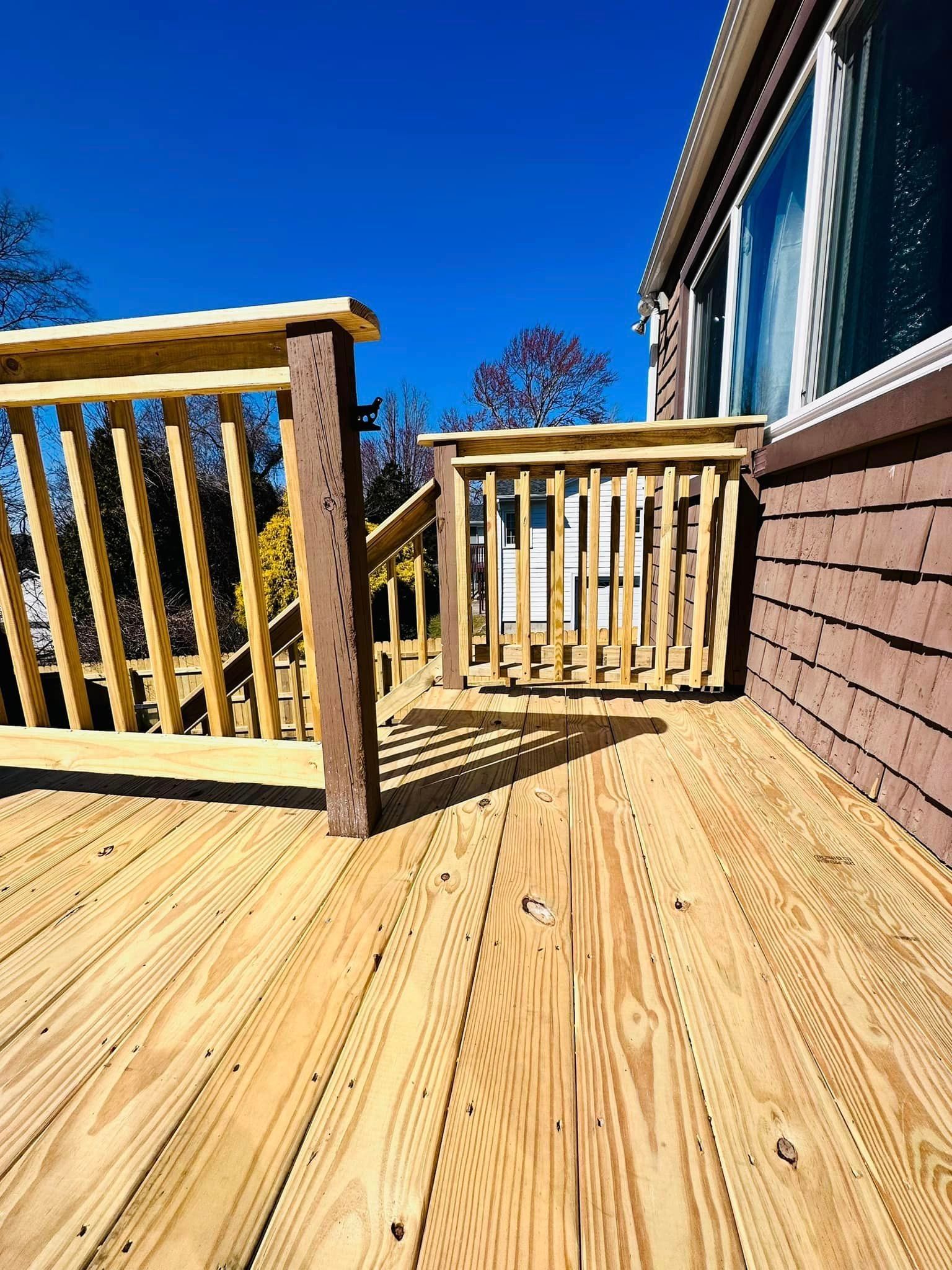 a wooden deck with a railing next to a house .