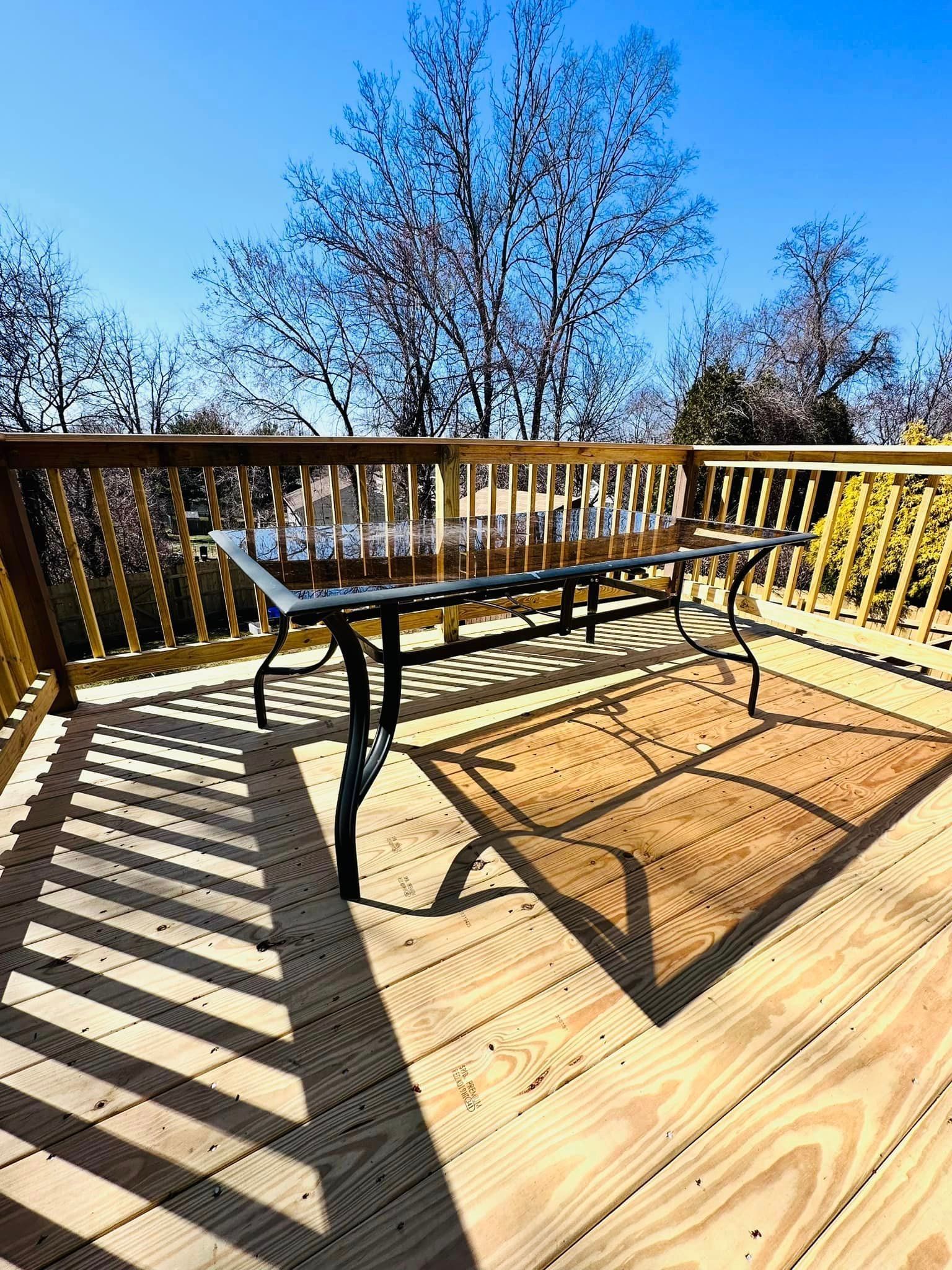 a wooden deck with a table and chairs on it .