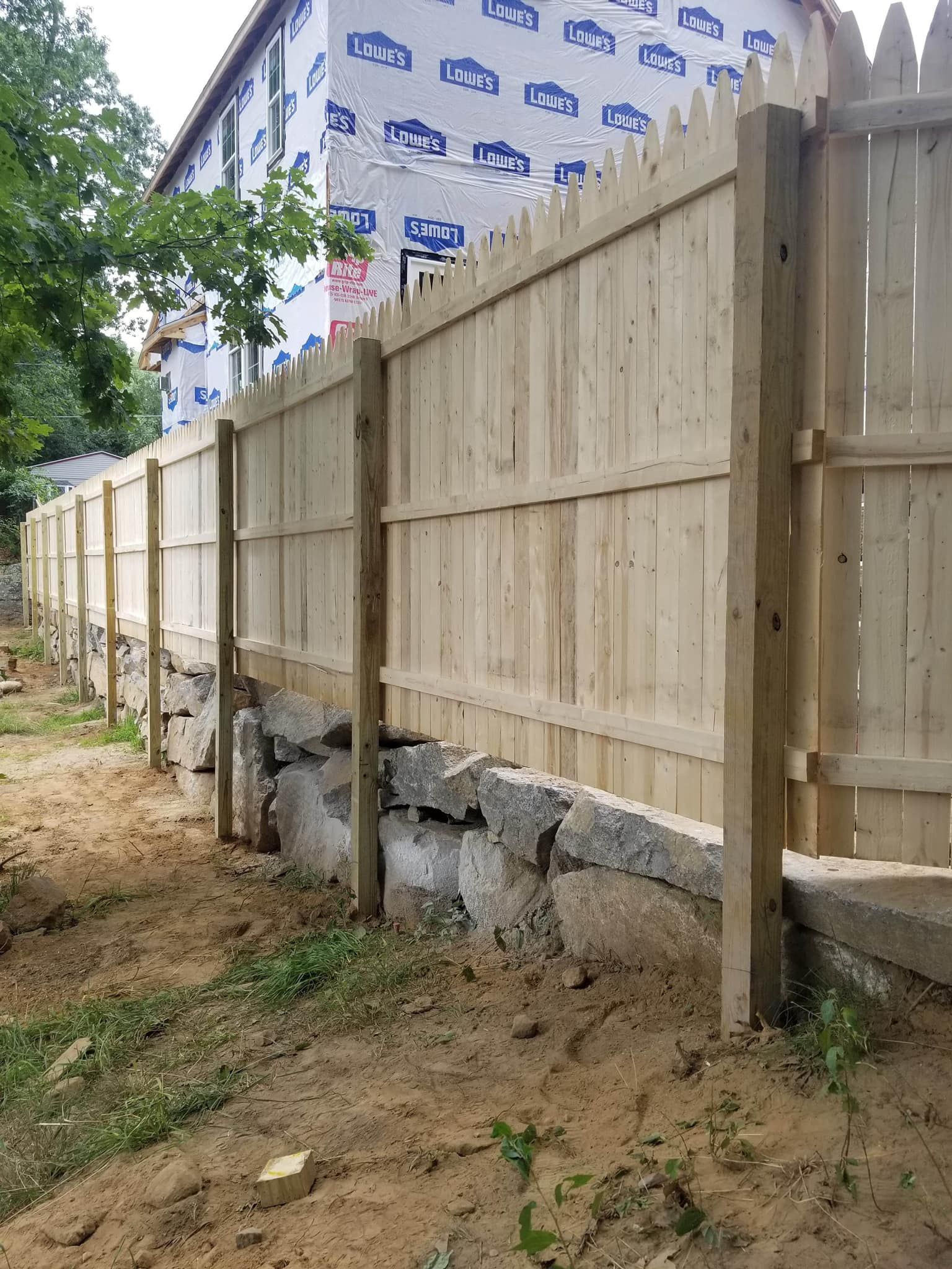 a wooden fence is being built in front of a house .