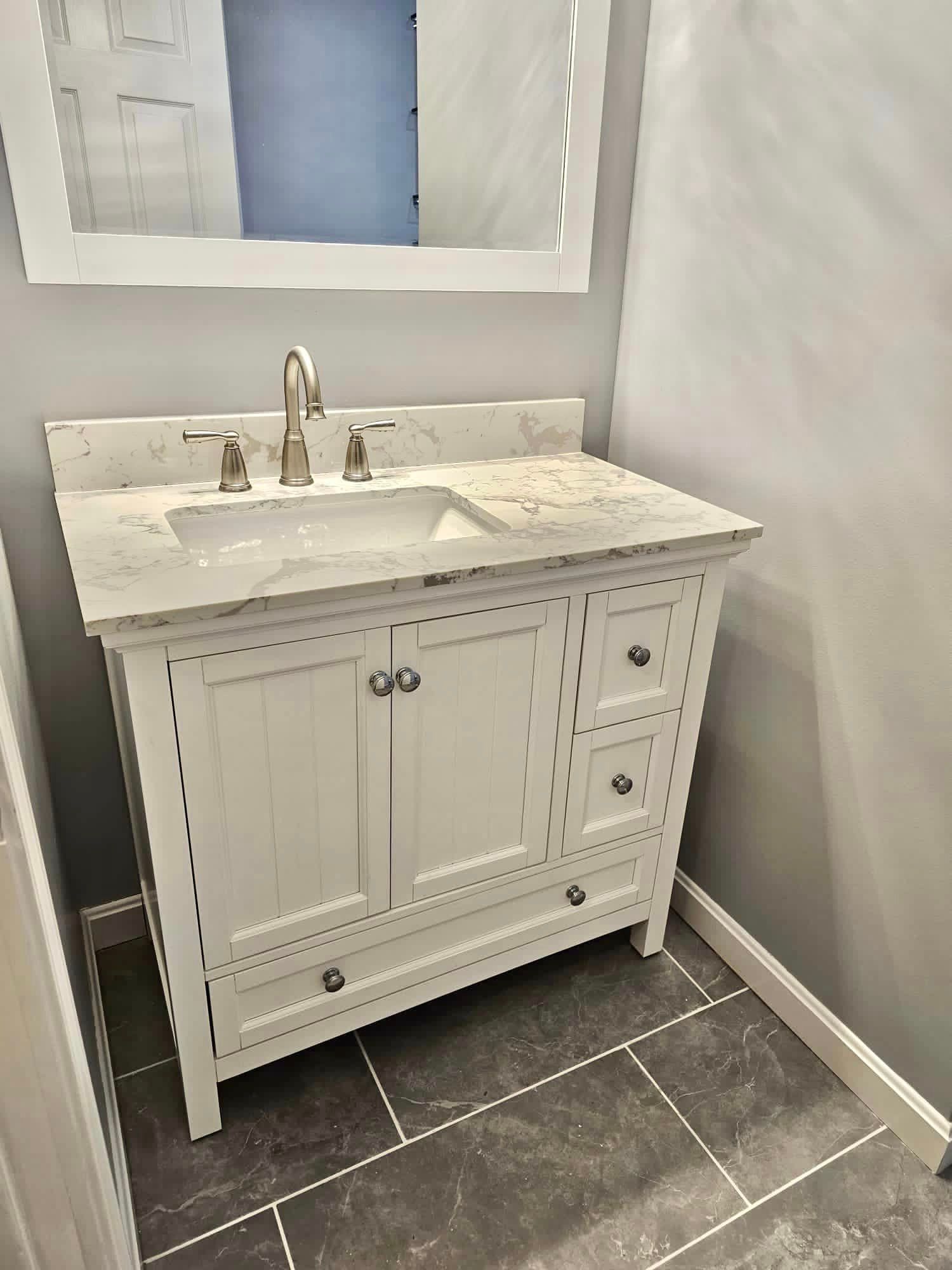 a bathroom with a sink , mirror and vanity .