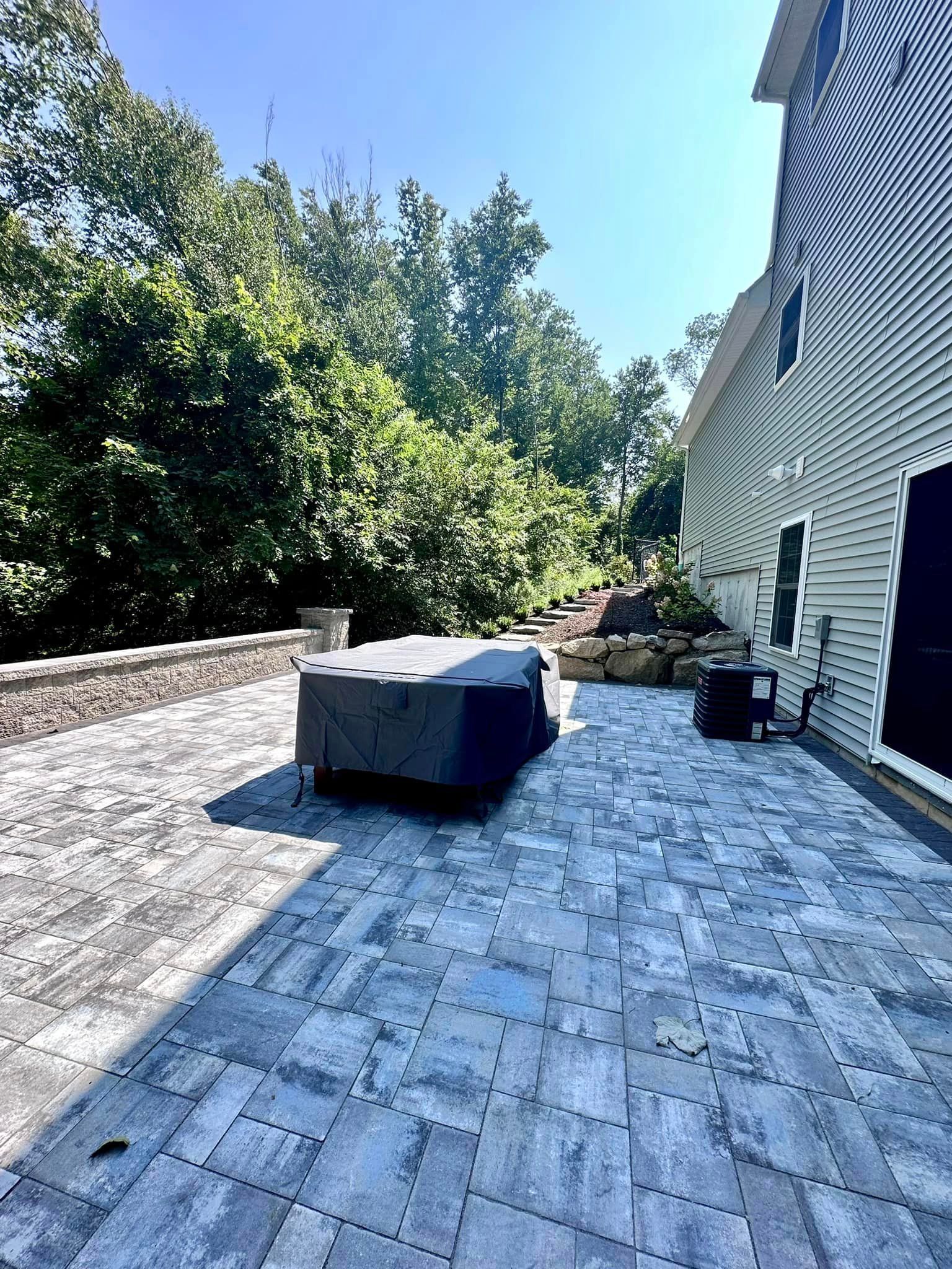a patio with a table and chairs in front of a house .