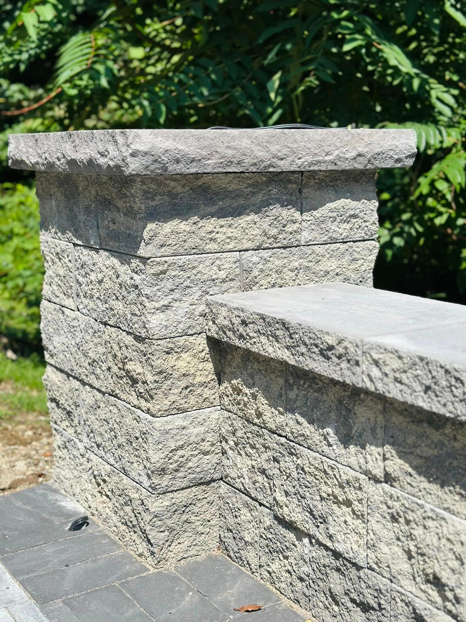 a stone wall with a bench on top of it .