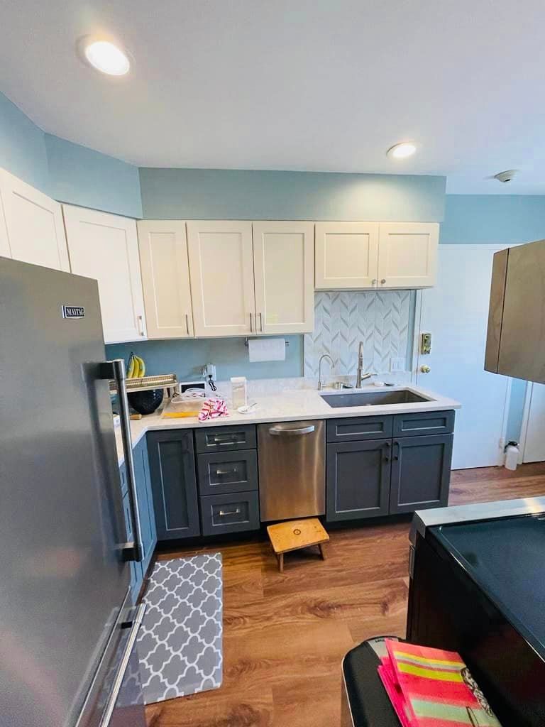 a kitchen with stainless steel appliances and gray cabinets .