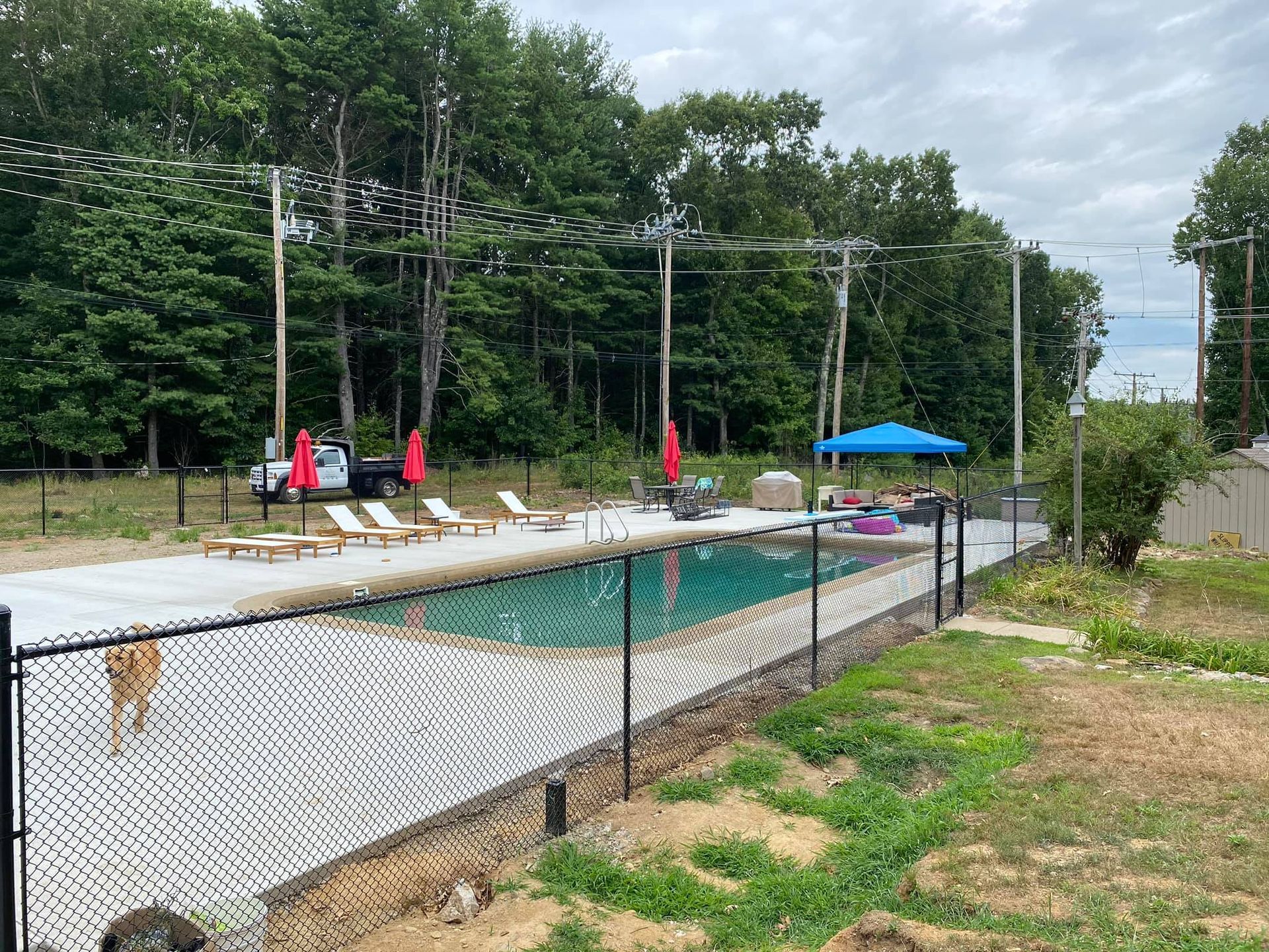 a large swimming pool is surrounded by a chain link fence .
