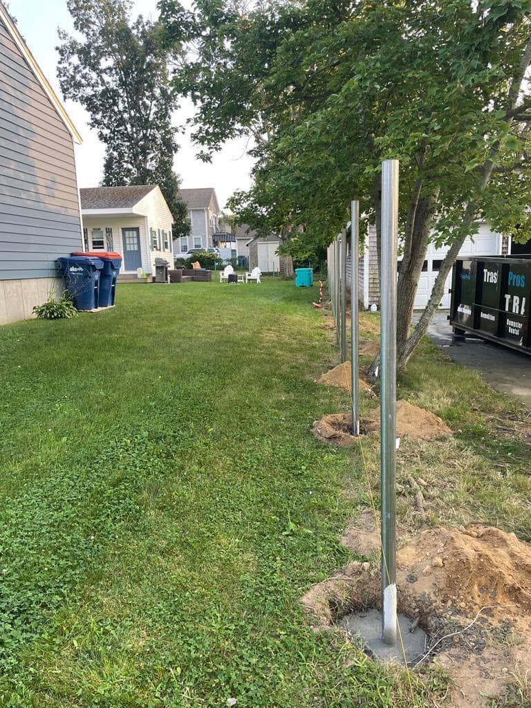 a fence is being built in the backyard of a house .