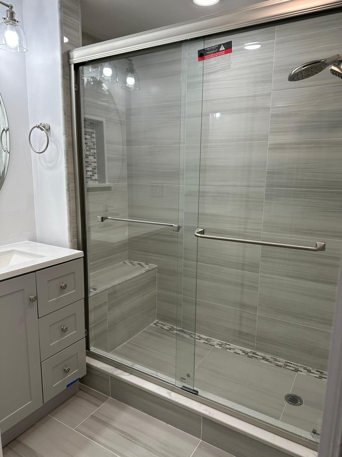 a bathroom with a sliding glass shower door and a sink .