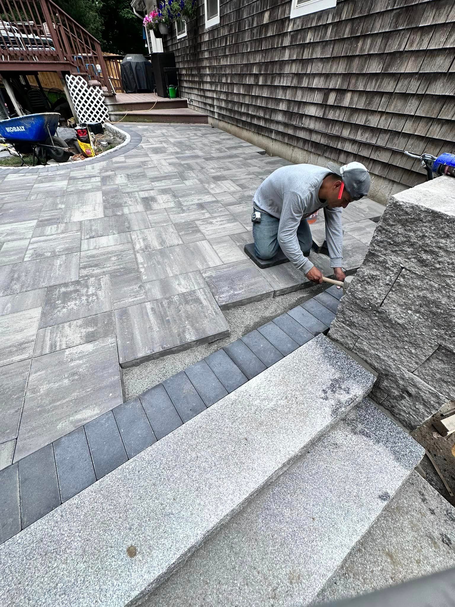 a man is kneeling down on a patio .