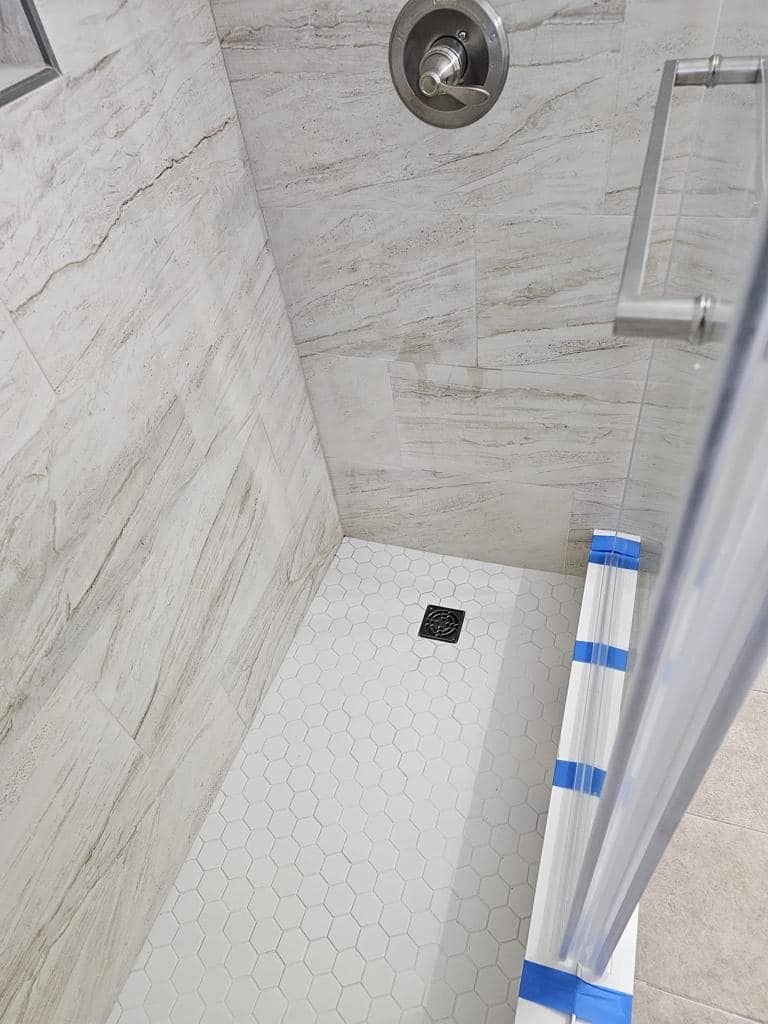 a shower stall with a sliding glass door and a shower head .