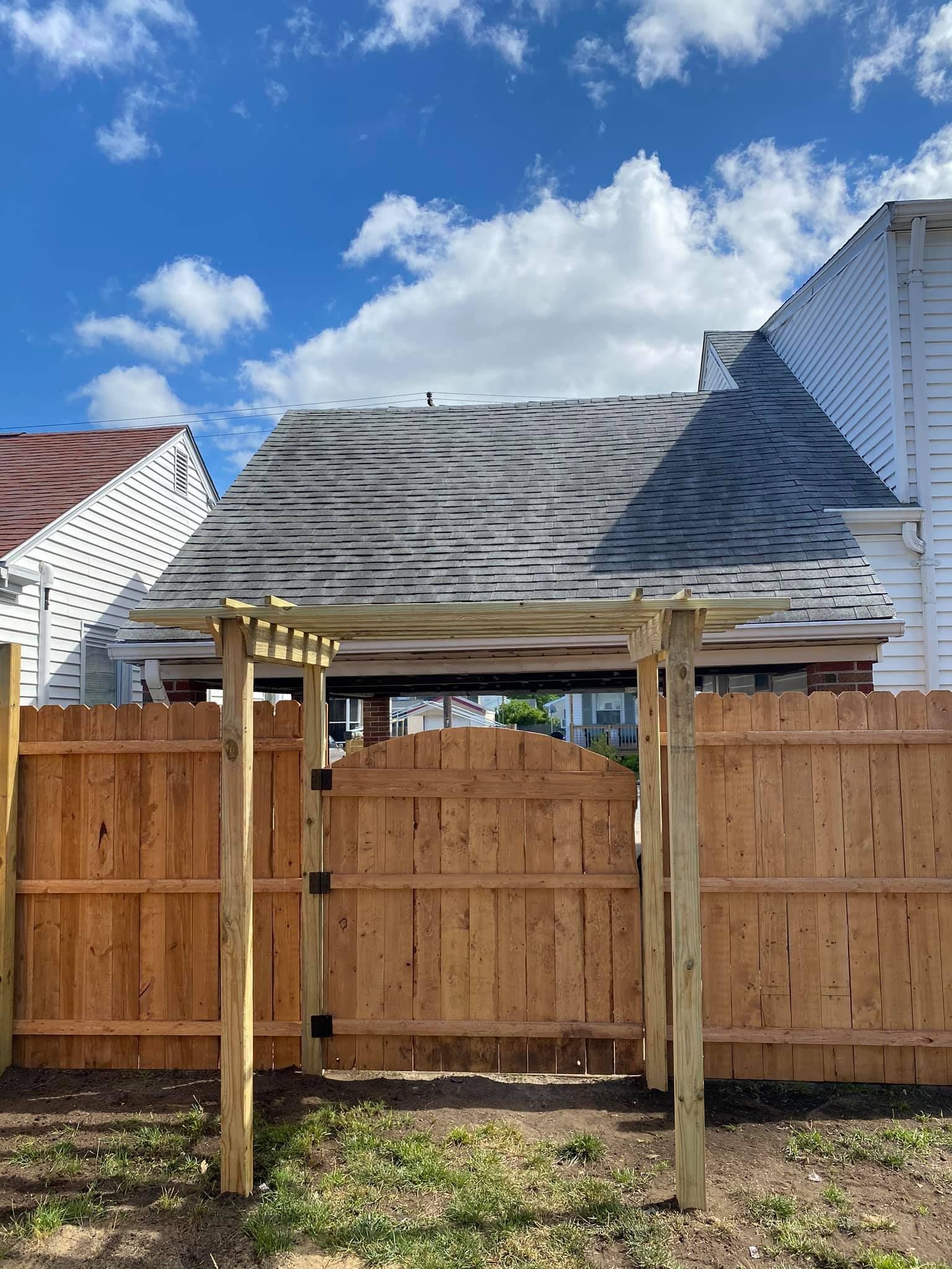 a wooden fence with a pergola in front of a house .