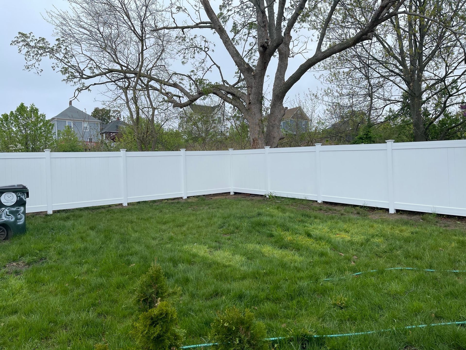 A white fence surrounds a lush green yard.