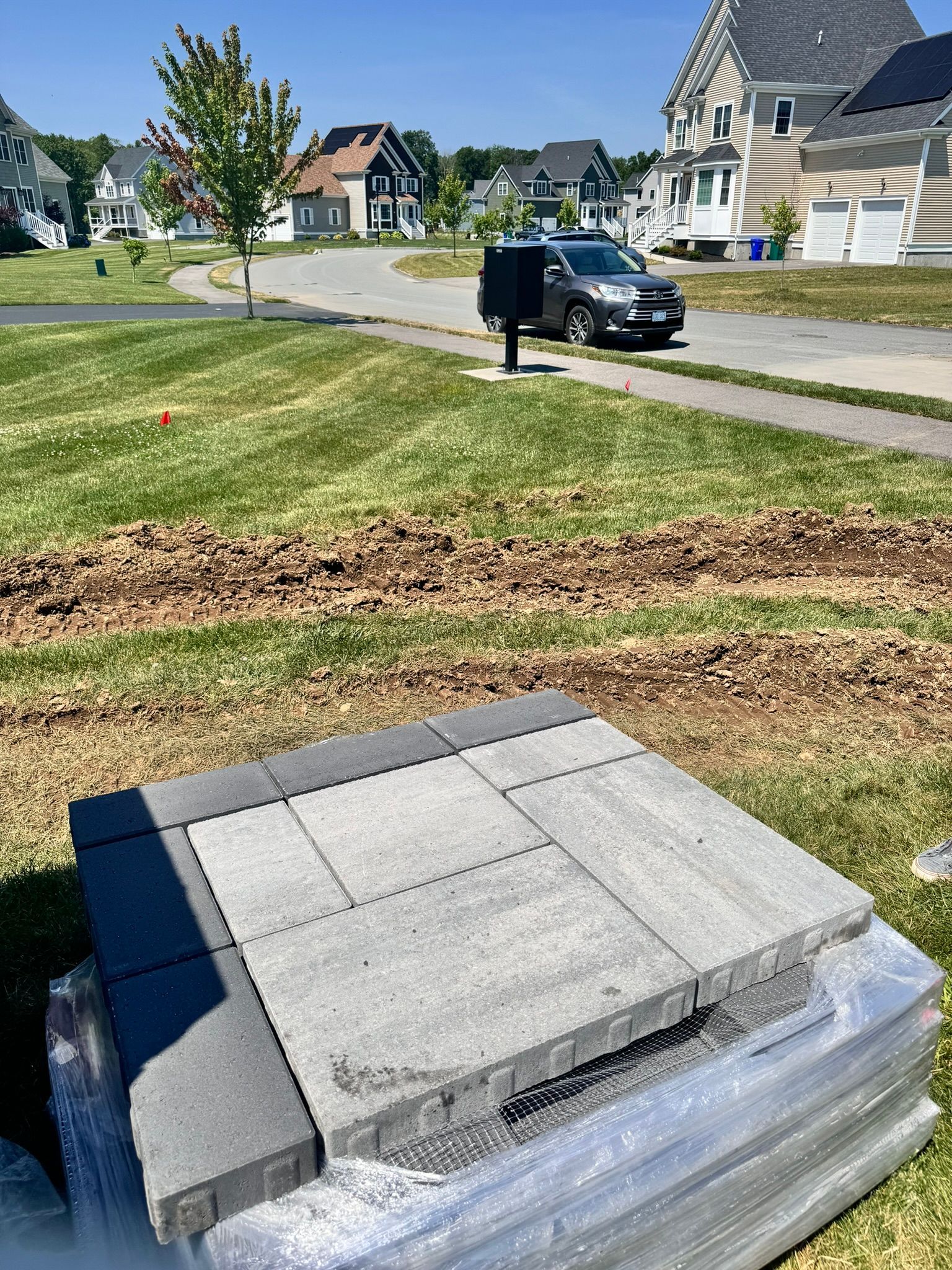 A stack of concrete tiles sitting on top of a lush green field