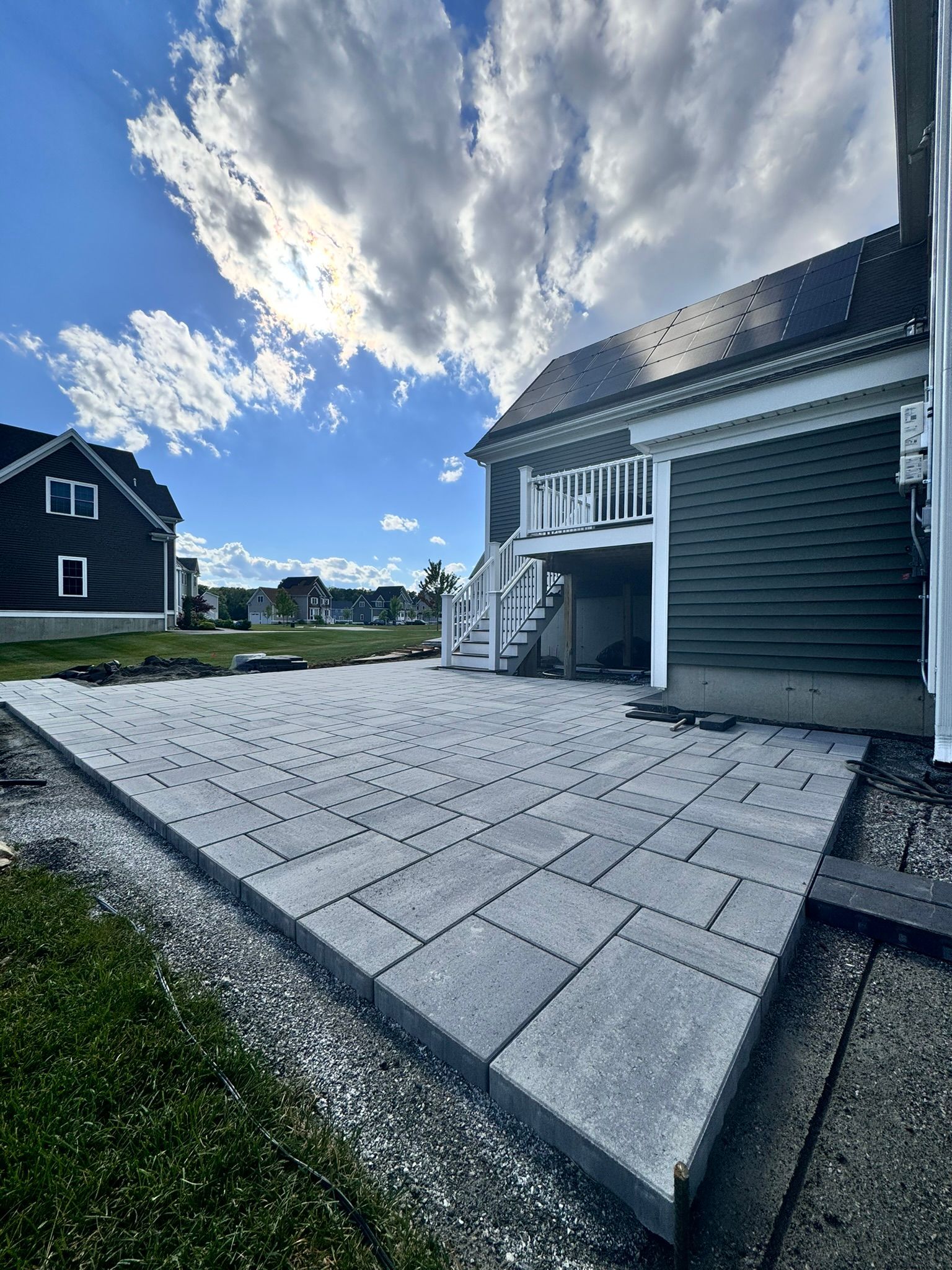 A driveway leading to a house with a garage and stairs