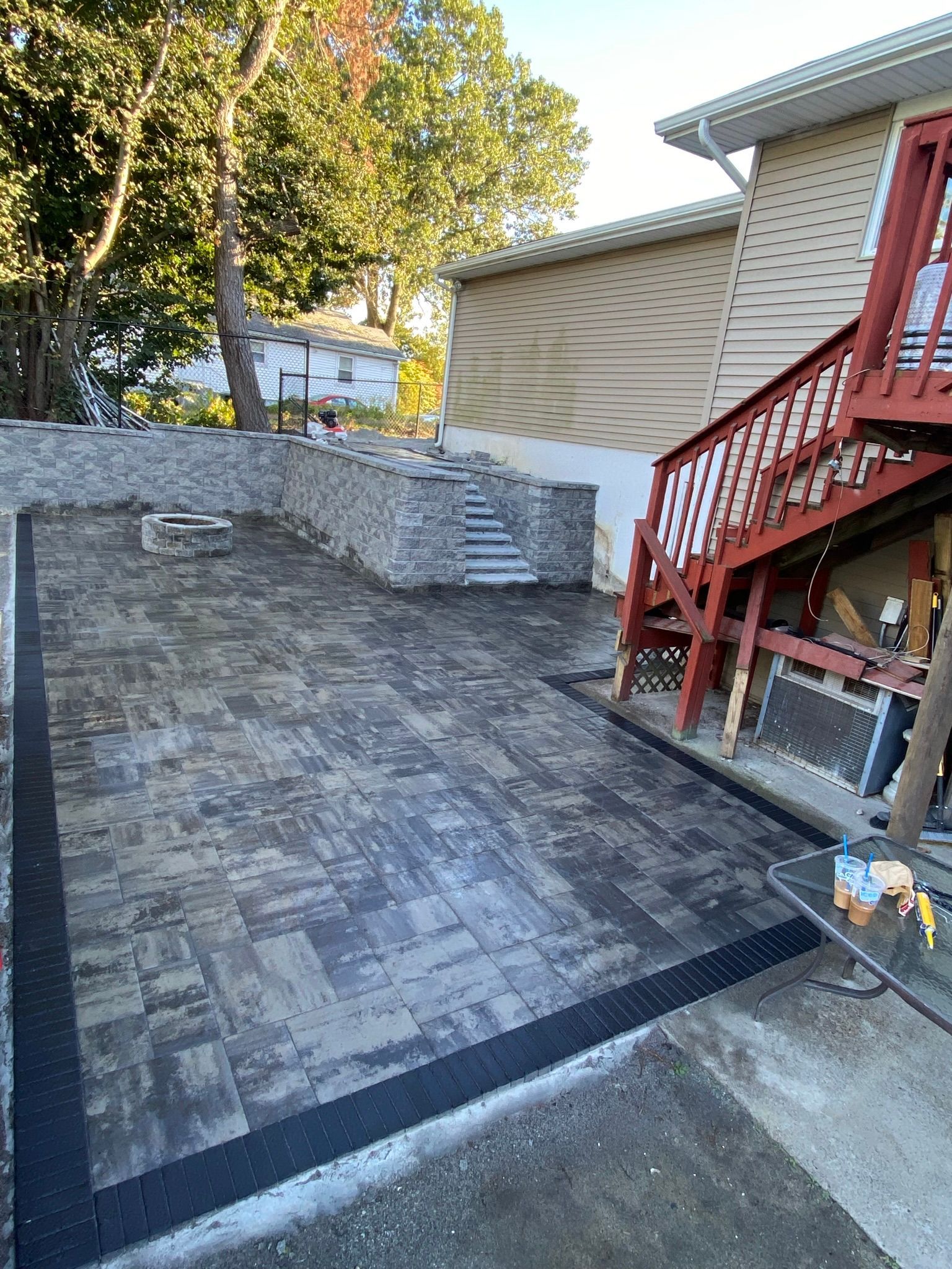 A patio is being built in front of a house with stairs