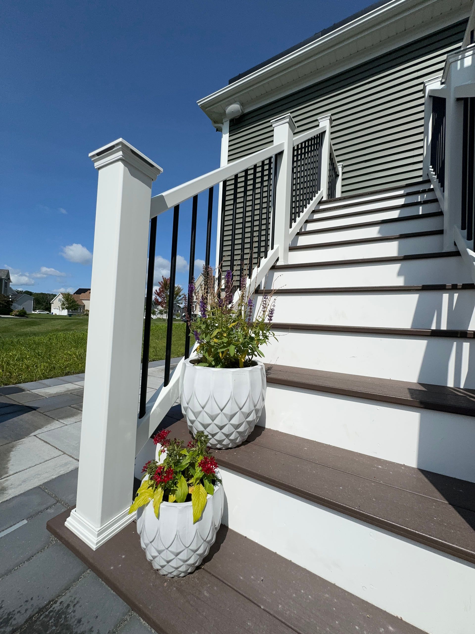 A set of stairs leading up to a house with potted plants on the steps.