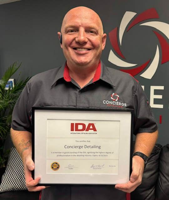 Man holding a framed certificate for