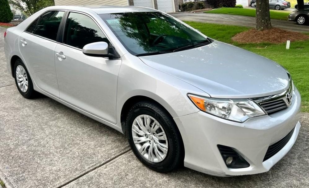 Silver Toyota Camry sedan parked on a concrete driveway.