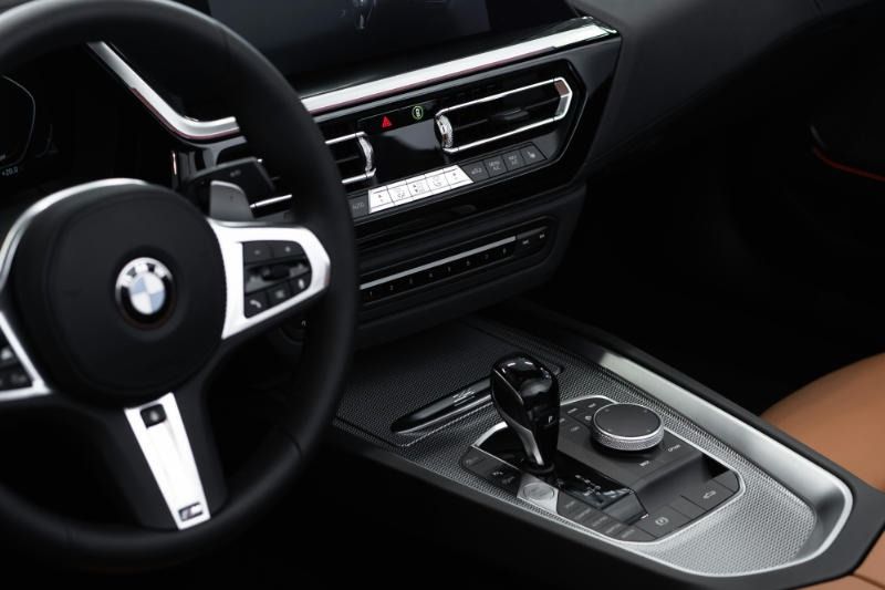 Interior of a black and silver BMW Z4 sports car; steering wheel, gearshift, and dashboard visible.