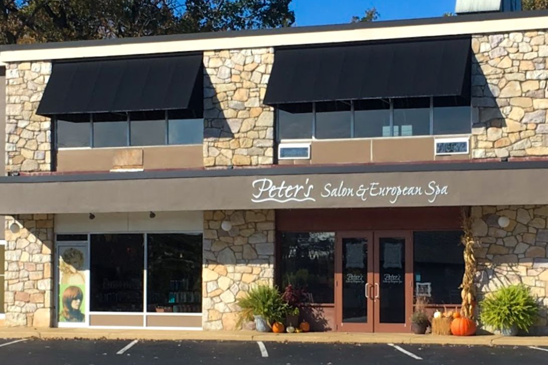 Learn More About Careers Exterior of Peter's Salon & European Spa, stone facade, black awnings, and large windows.