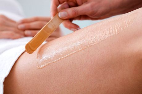 a woman is getting a wax on her leg