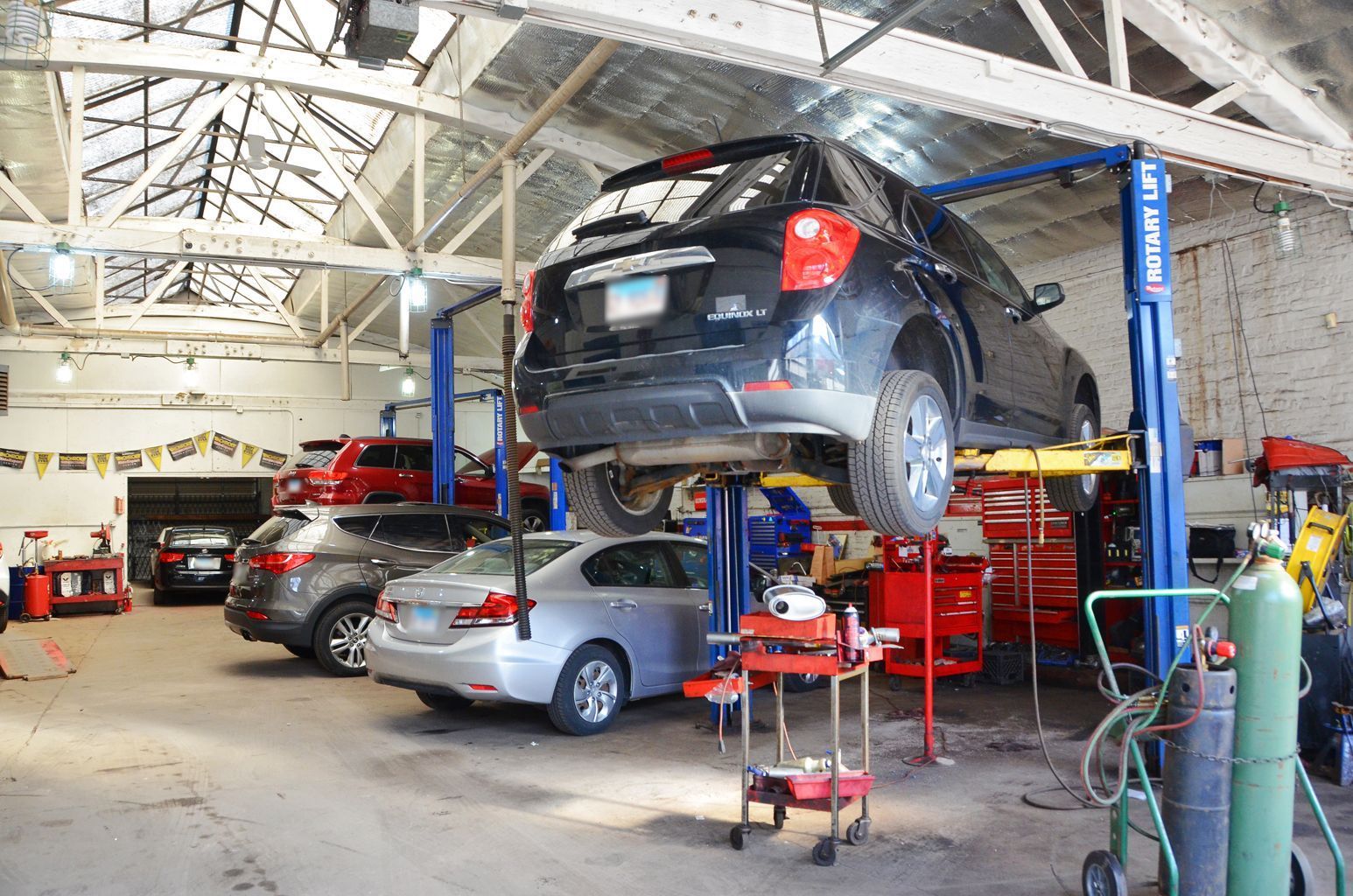A car is sitting on a lift in a garage.