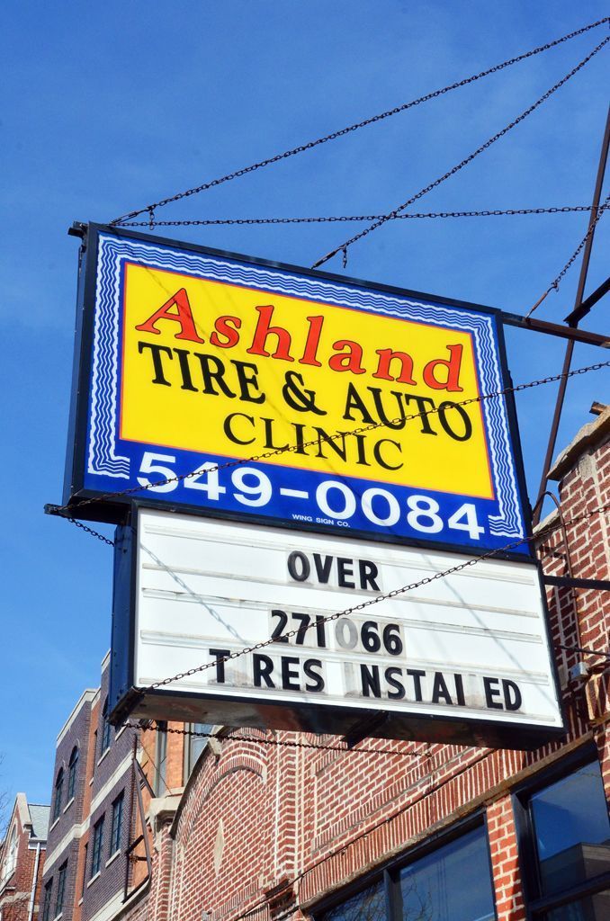 A yellow sign for ashland tire and auto clinic