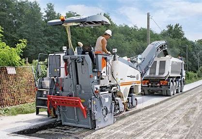 A man is driving a machine on a road.