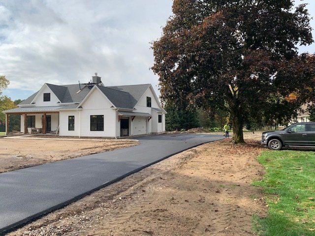 white gray house with asphalt driveway