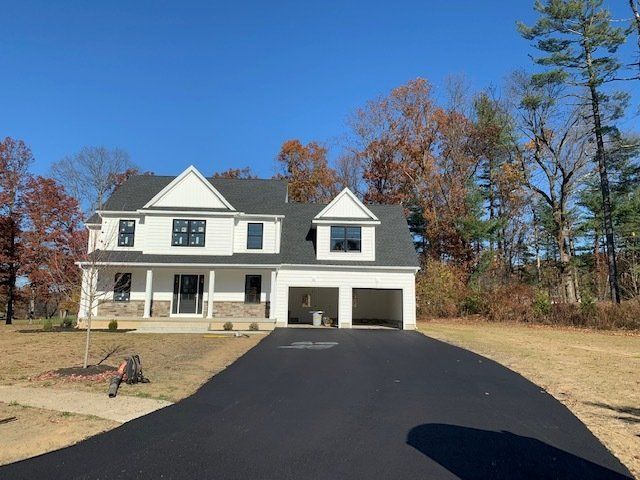 white gray house with new asphalt driveway