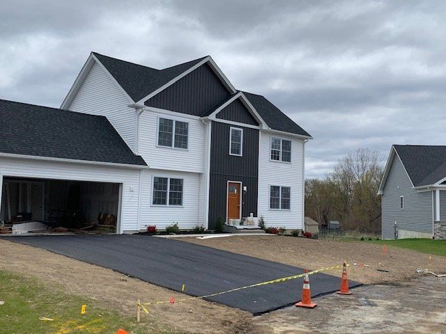 White house with asphalt driveway paving