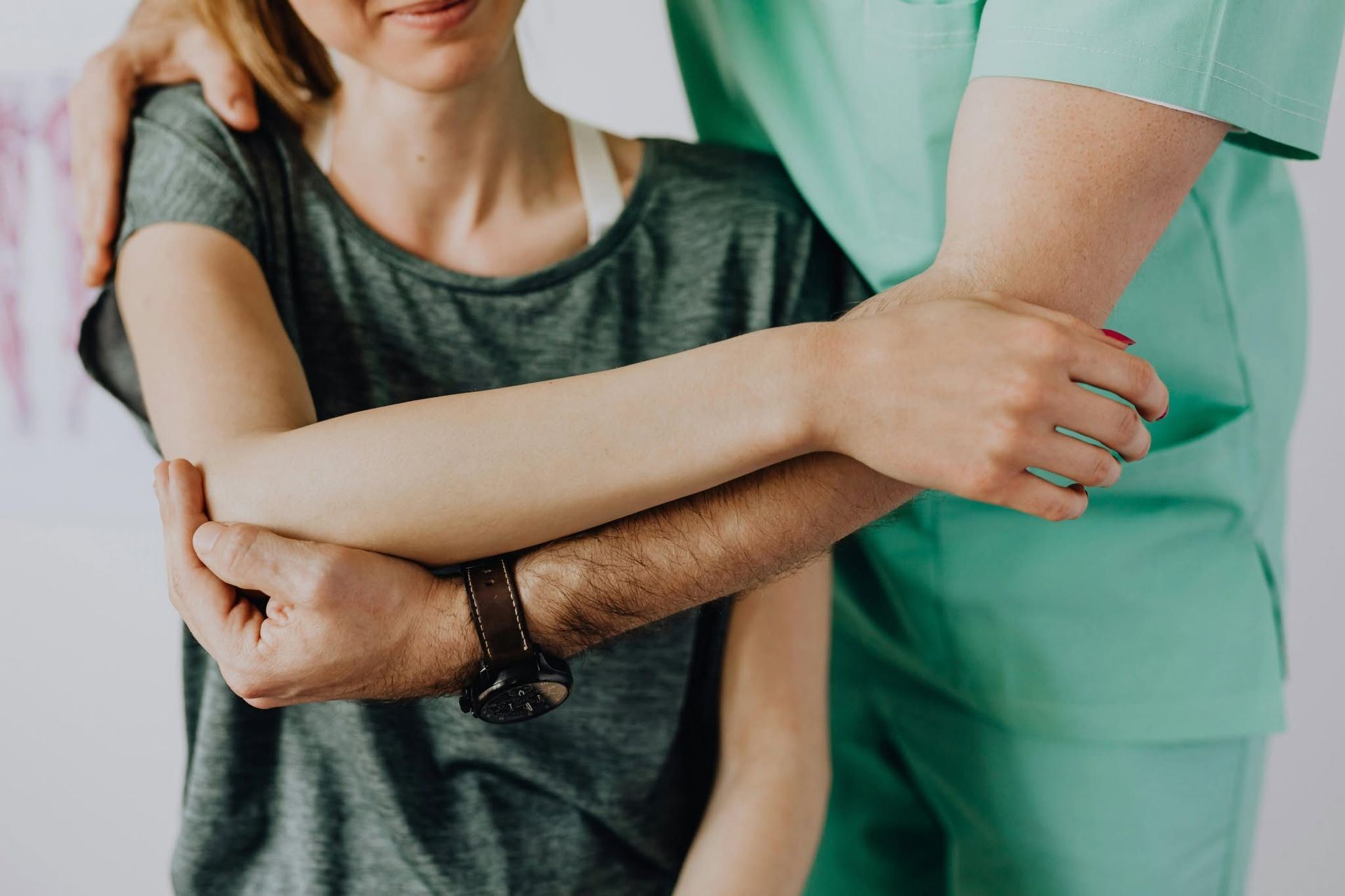 Healthcare worker supporting a seated patient with an arm around their shoulders