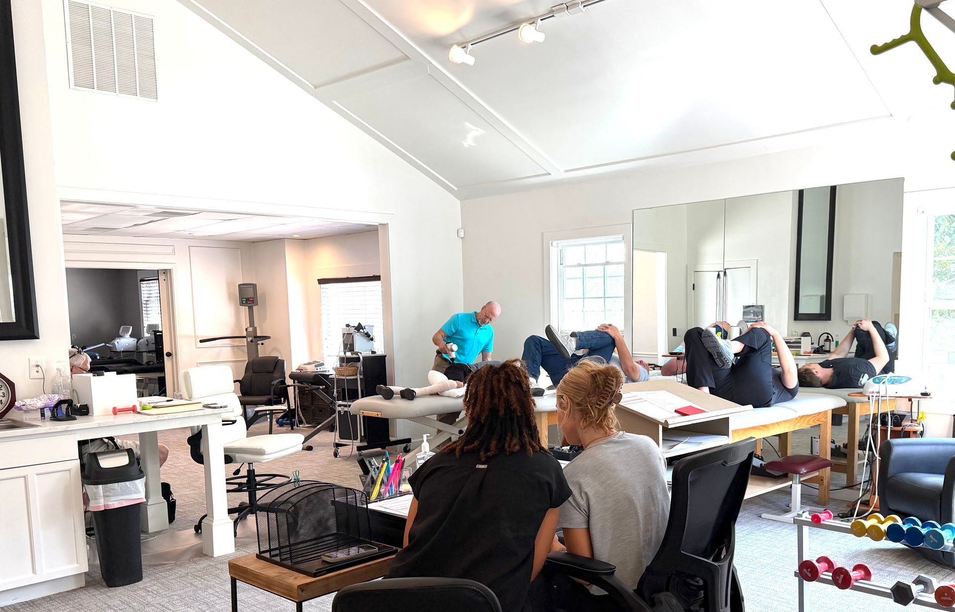 Hair salon interior with stylists working on seated clients near mirrors and tools