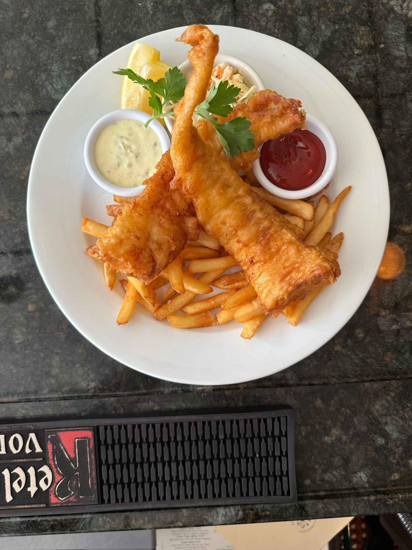 A white plate topped with fried fish and french fries