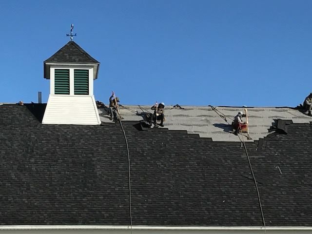 A group of people are working on the roof of a building.