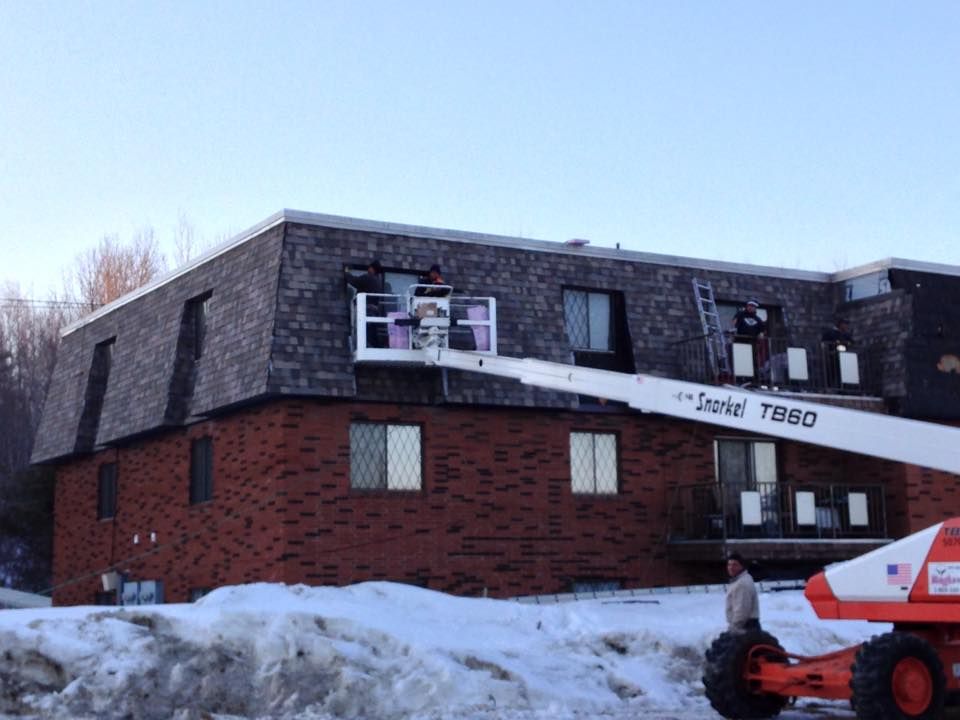 A large brick building with a crane on the side of it.