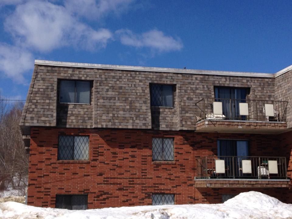 A brick building with a balcony in the snow