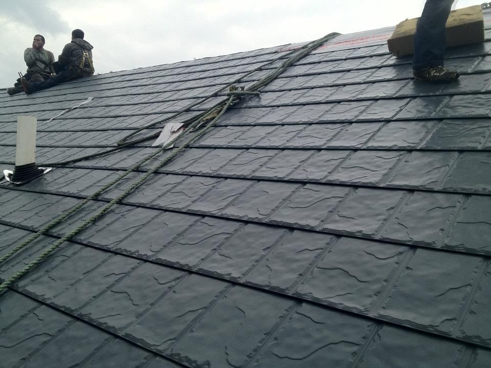 Two men are sitting on the roof of a building.