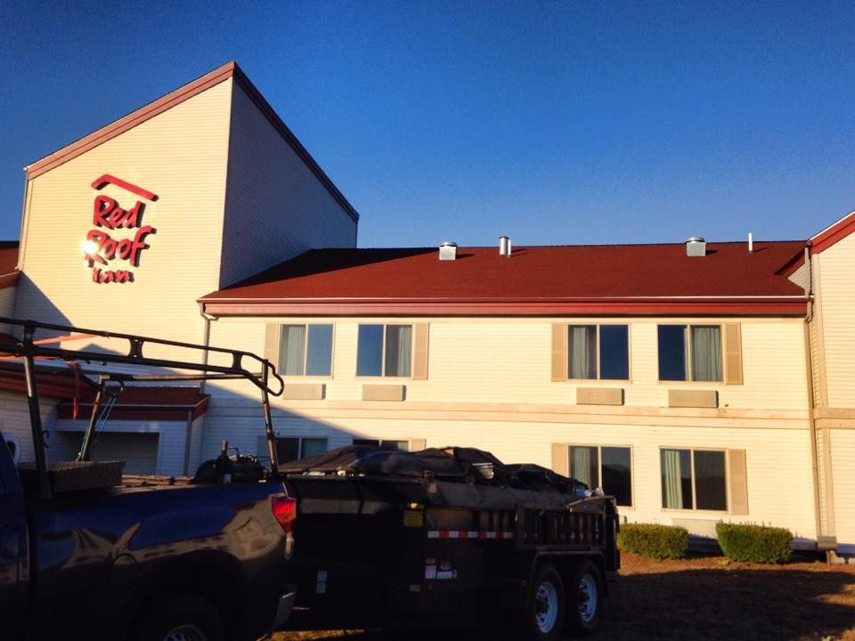 A truck is parked in front of a red roof inn